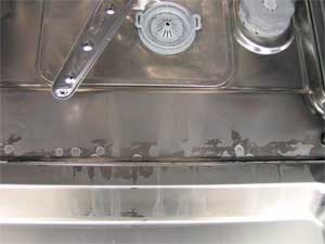 Sisa putih pada pinggan mangkuk dan dalam mesin basuh pinggan mangkuk