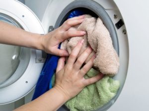 skalbimo mašinos būgno perkrovimas skalbiniais