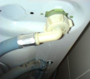 מים זורמים מלמטה מתחת למכונת הכביסה של אטלנט