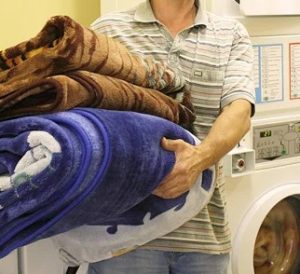 Eine große Decke in der Waschmaschine waschen