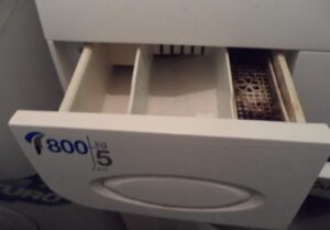 Come rimuovere il vassoio della polvere dalla lavatrice Ardo?