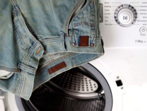Should I use a spin cycle when washing jeans in a washing machine?